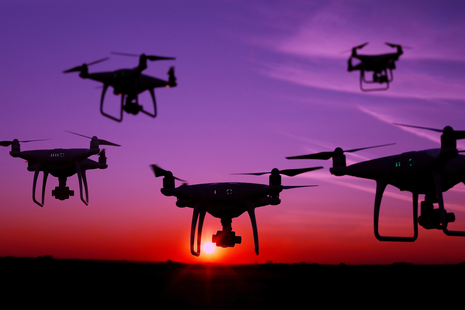 Five drones in the sky at sunset